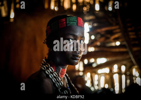 Hamer girl tribe inside her hut Stock Photo