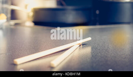 pair of chopsticks placed on a work surface gray antracite in a kitchen Stock Photo