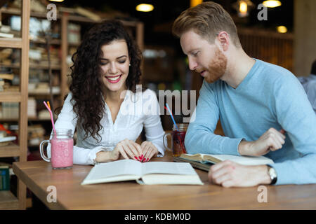 Young students spending time in coffee shop reading books Stock Photo