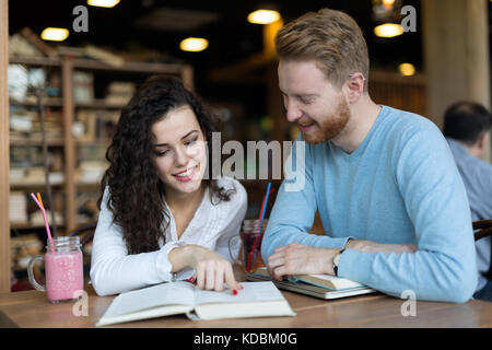Young students spending time in coffee shop reading books Stock Photo