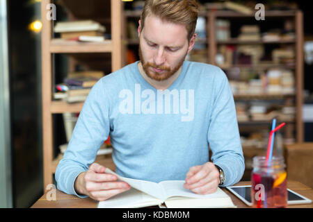 Young handsome student learning in coffee shop Stock Photo