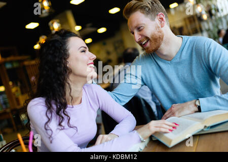 Young students spending time in coffee shop reading books Stock Photo