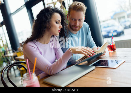 Portrait of young students reading book and talking Stock Photo