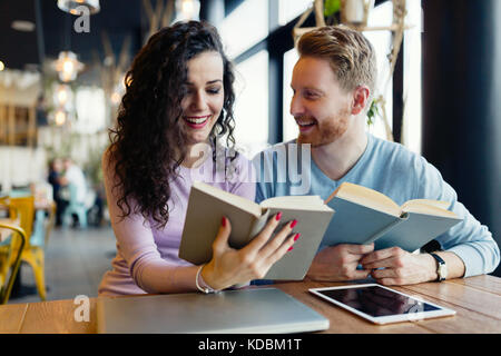 Young students spending time in coffee shop reading books Stock Photo