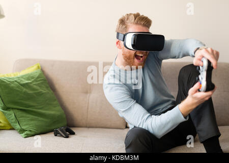 Handsome man playing video games with virtual reality headset Stock Photo