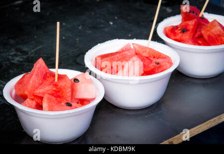 Fresh watermelon slice in white foam plate container on black wooden table Stock Photo