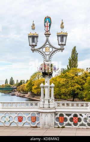 Old twin Lamp Lights on a single lamp post on the Bridge with white railings and small red shields over the River Ouse in York North Yorkshire England Stock Photo