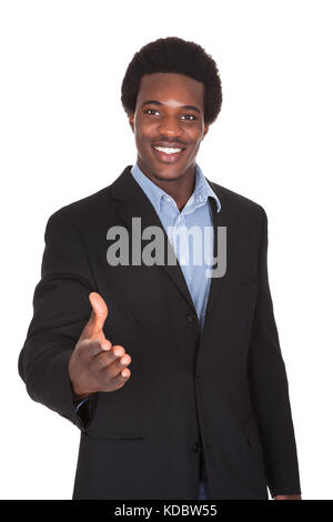 Happy Young Businessman Extending Hand To Shake Stock Photo