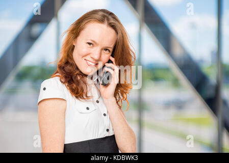 Charming secretary with a phone in his hand in the office Stock Photo