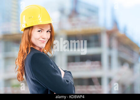 portrait of a female architect in a yellow helmet at a construction site Stock Photo