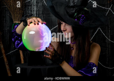 a girl in a black hat works as a fortune-teller, looks carefully into the ball of fate Stock Photo