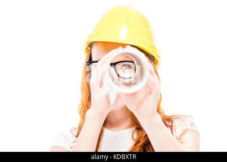 Portrait of a woman builder who looks through blueprints as in a telescope on a white background Stock Photo