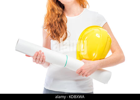 A yellow hard hat and projects on paper in the hands of a close-up woman Stock Photo