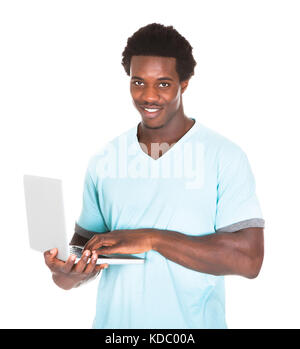 Happy Young African Man Using Laptop Isolated Over White Background Stock Photo