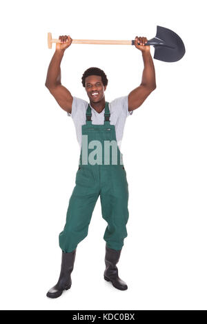 Happy Male Gardener Holding Shovel Over White Background Stock Photo