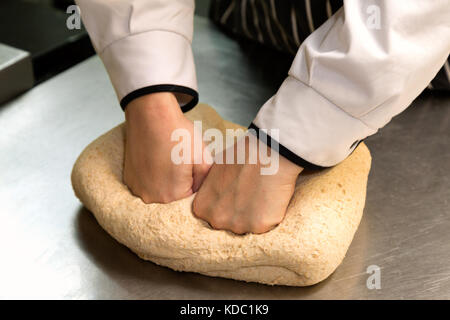 Bread making - A cook kneading dough  making bread, England UK Stock Photo