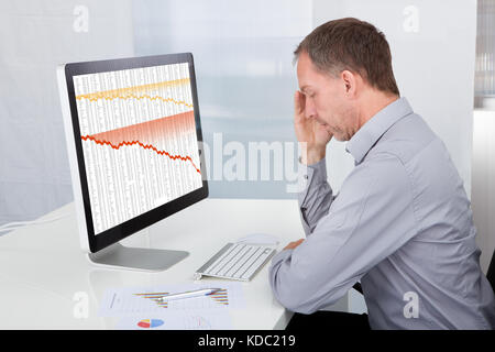 Portrait Of Mature Tired Businessman Sitting In Office Stock Photo