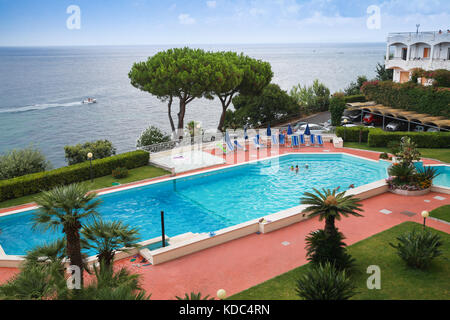 Lacco Ameno, Italy - August 15, 2015: Coastal landscape with ordinary people resting near swimming pool. Ischia island, Italy Stock Photo