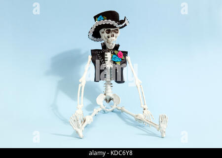 Mexican skeleton celebrating el dia de los muertos on a blue vibrant pop background. Minimal color still life photography Stock Photo