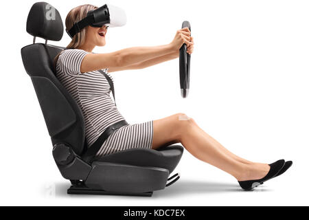 Woman with a VR headset sitting in a car seat and holding a steering wheel isolated on white background Stock Photo