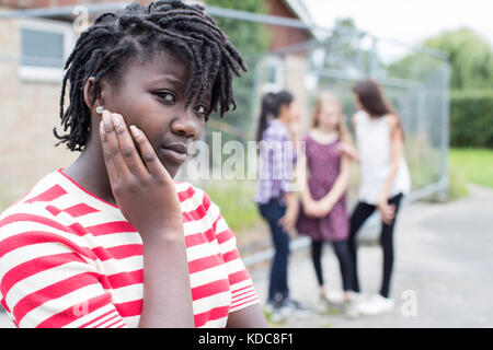 Portrait Of Sad Teenage Girl Feeling Left Out By Friends Stock Photo