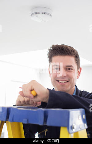 Man Installing Smoke Or Carbon Monoxide Detector Stock Photo