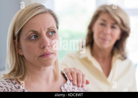 Mature Mother Concerned About Adult Daughter At Home Stock Photo