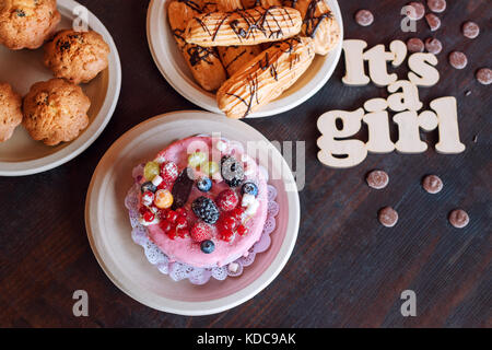 Sweet cheese cake with fresh berries and yoghurt cream and wooden sign Its A Girl. Baby shower party sweets. Stock Photo