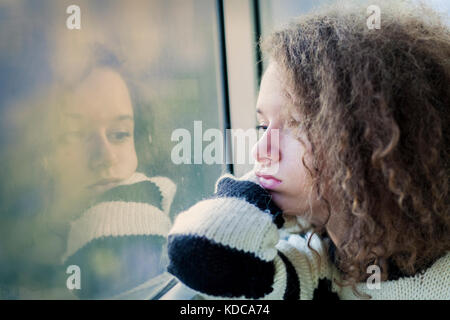 Portrait of the serious teenage girl sitting by the window Stock Photo