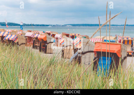 Colorfuled striped roofed chairs on sandy beach in Travemunde., Lubeck, Germany Stock Photo