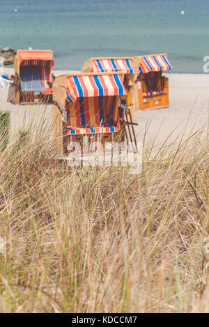 Colorfuled striped roofed chairs on sandy beach in Travemunde., Lubeck, Germany Stock Photo