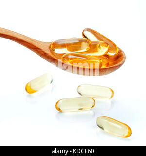 Spoonful of gel capsules of omega 3. Close up capsules fish oil in wooden spoon .The supplement high vitamin E, omega 3 and DHA . Capsules fish oil wi Stock Photo