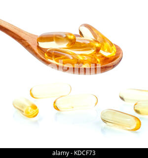 Spoonful of gel capsules of omega 3. Close up capsules fish oil in wooden spoon .The supplement high vitamin E, omega 3 and DHA . Capsules fish oil wi Stock Photo