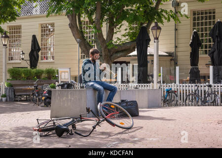 A man playing trumpet on a city square in Amsterdam, The Netherlands. Stock Photo