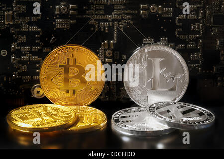 the Litecoin adn Bitcoin coins are  decentralized open-source crypto-currency in the background of a motherboard with microcircuits Stock Photo