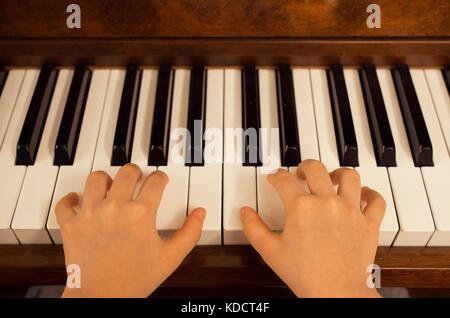 Close up of young girl playing piano at home Stock Photo