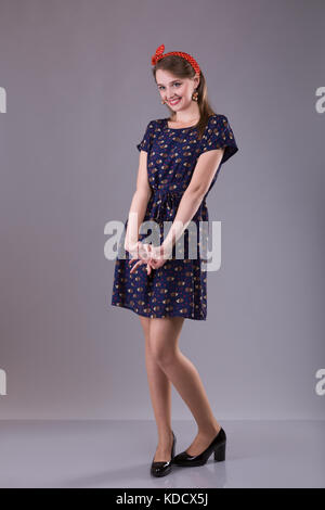 beautiful positive girl is shy and smile on gray background Stock Photo