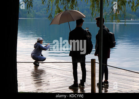 Tourists taking photographs beside Lake Bled in Bled, Slovenia. Stock Photo