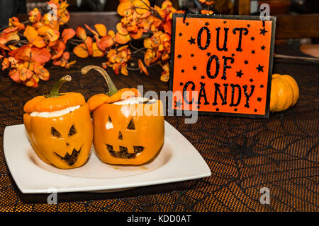 Vegetarian Jack-o-Lantern stuffed Peppers served at a Halloween Party Stock Photo