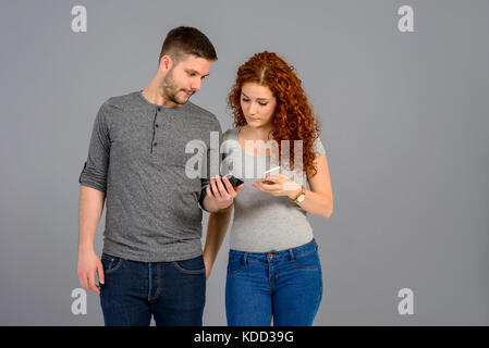 A handsome young man showing his smartphone to his beautiful girlfriend Stock Photo