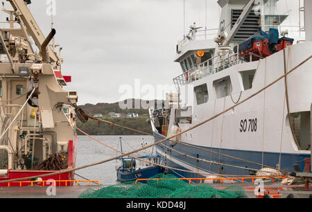 An old fishing boat moored between two modern fishing boats in Killybegs, Ireland. Stock Photo