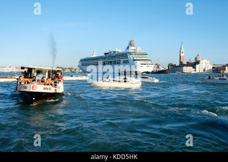 Congestion in the Venetian lagoon as the the Royal Caribbean Cruise ship, 'Rhapsody of the Seas' makes its way past San Giorgio Maggiore. Venice, Ital Stock Photo