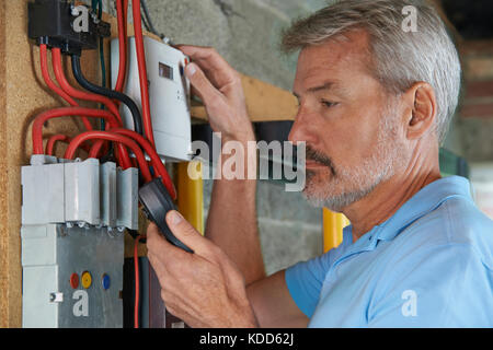Man Taking Reading From Electricity Meter Stock Photo