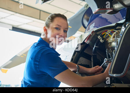Portrait Of Female Aero Engineer Working On Helicopter In Hangar Stock Photo