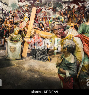 Via Crucis of Jesus Christ, in a Passion of Christ biblical scene a woman show his child a Jesus Christ bringing his cross before his Crucifixion Stock Photo