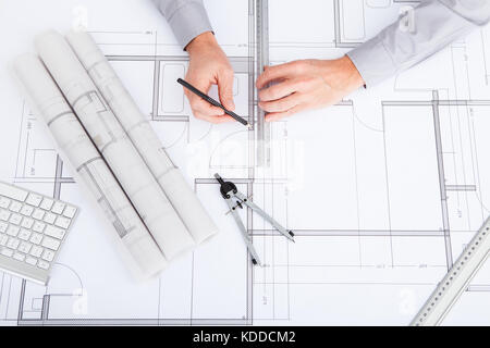 Close-up Of Person's Hand Drawing Plan On Blue Print Stock Photo