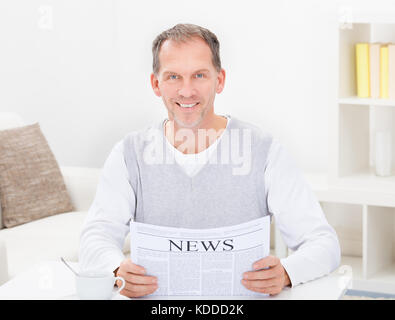 Mature Man Reading Newspaper While Having Coffee Stock Photo