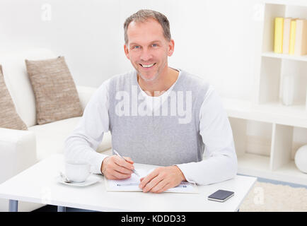 Mature Man Reading Newspaper While Having Coffee Stock Photo