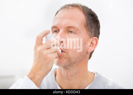 Man With Asthma Using An Asthma Inhaler For Preventing Attacks Stock Photo