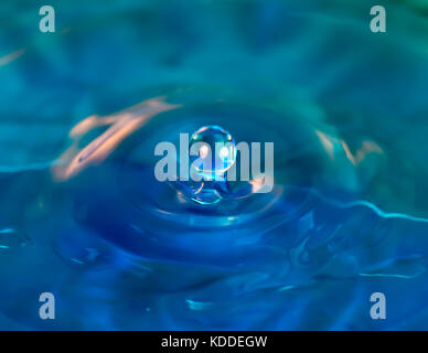 Close up drop splashing in blue water Stock Photo